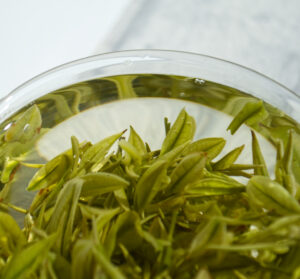 close up of green tea leaves in glass cup